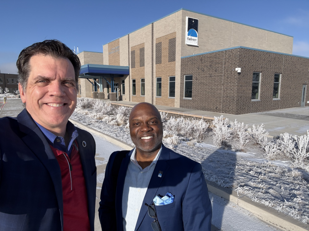 Two men stand outside Challenger Learning Center of Colorado.